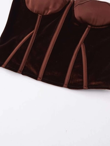 Close-up of brown velvet and satin corset top featuring structural boning detail
