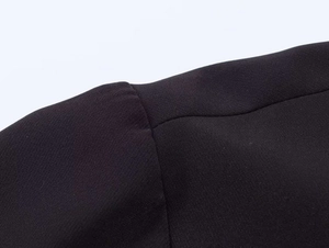 Close-up of the professional stitching and cotton fabric texture on a black polo shirt
