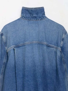 Detailed back view of a blue denim jacket with unique pleats and curved hem design