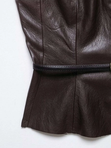 Detail of dark brown faux leather texture with waist belt and fine stitching accents