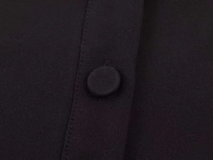 Detailed macro view of the black contrast polo shirt with premium fabric covered button