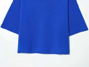 Détail du pull en maille bleu roi montrant l'ourlet lisse et le tissu texturé fin