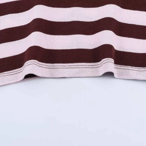 Close-up of brown and white striped knit fabric showing high-quality hem stitching detail