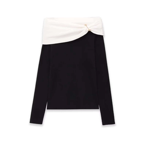 Elegant off-shoulder black knit sweater with contrast white folded neckline and gold pin