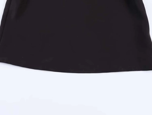 Detail of the smooth black fabric texture and fine hem stitching on this polo top
