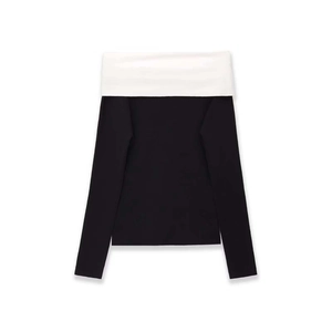 Detail of the elegant black and white contrast knit top with a stylish off-shoulder neckline