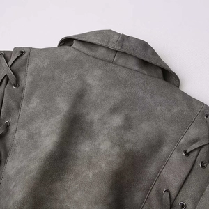 Dettaglio della giacca in scamosciato grigio con revers vintage e occhielli stringati