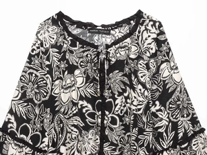 Dettaglio top da donna con stampa paisley, colletto a balze e lacci neri regolabili