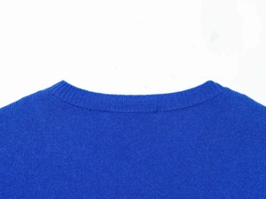 Détail d'un pull en maille bleu roi montrant le col rond et la texture fine côtelée