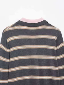 Detail view of striped knit sweater featuring contrast pink collar and neutral patterns