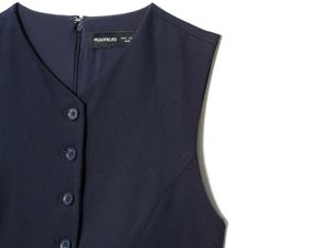 Detail of navy blue V-neck sleeveless vest with buttons and interior brand label