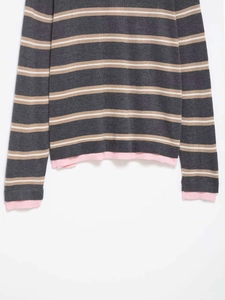 Detailed macro view of gray and white striped knit sweater with pink ribbed cuff detail