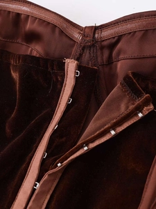 Macro view of dark brown velvet corset top showing metal hook-and-eye closure details