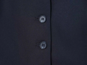 Close-up of black twill fabric and dark grey marble textured buttons on a slim dress