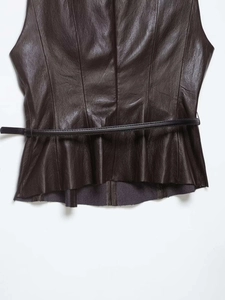 Detail of dark brown faux leather vest with belted waist and premium pebble texture
