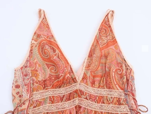 Detail shot of the V-neck lace trim and bohemian paisley print fabric on the summer dress