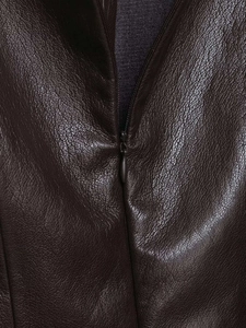 Close-up of brown faux leather texture with hidden zipper detail and pebbled grain finish