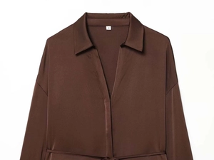Detail of satin shirt collar and white size tag on dark brown silk-like fabric