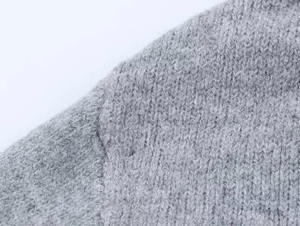 Detailansicht des grauen Stern-Jacquard-Strickstoffs mit Fokus auf die Schulternaht