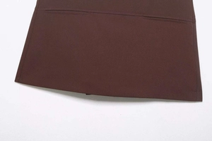 Détail d'une mini-jupe marron foncé en tissu tissé avec coutures nettes et poche latérale