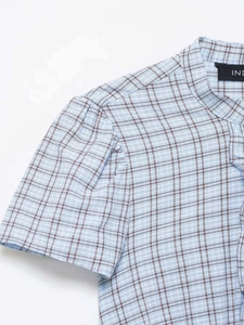Close-up of light blue plaid dress showing stand collar and pleated puff sleeve details