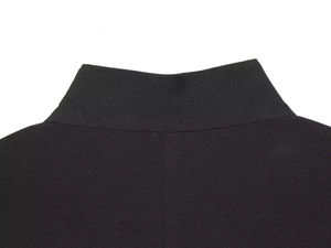 Detail of the mandarin collar on a minimalist black suit jacket with clean stitching