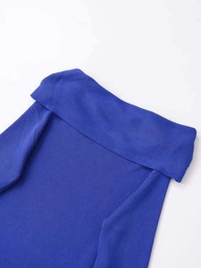 Detail of royal blue knitted sweater showing the elegant twist-knot off-shoulder neckline