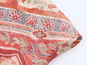 Detailed close-up of paisley print fabric and neat hem stitching on the flowy dress