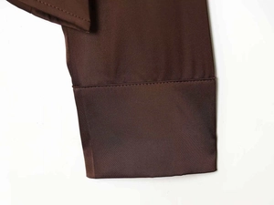 Macro shot showing the smooth satin texture and neat stitching of dark brown shirt cuffs