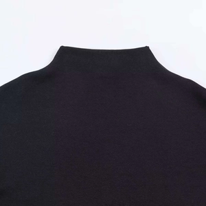 Detailed close-up of a premium black mock neck knit dress featuring clean seam stitching