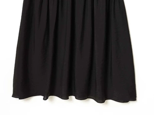 Detailed close-up of black pleated fabric texture on waist of this chic summer dress