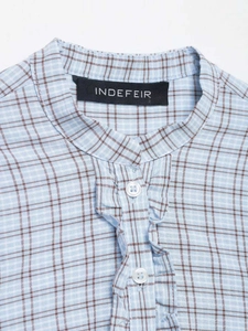 Detail view of the stand collar and ruffle trim on the blue checkered shirt dress