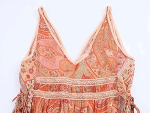 Close-up of paisley print dress with lace V-neckline and hollow lace waist detailing