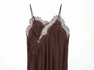 Detailed view of brown satin dress featuring delicate eyelash lace trim on the V-neckline