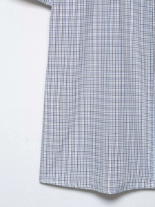 Détail du tissu à carreaux bleus et blancs et coutures sur manches bouffantes