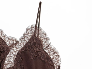 Detailed close-up of dark brown camisole with delicate eyelash lace trim and satin fabric