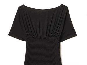 Detail of the smocked elastic waist and gathered fabric on this black summer dress