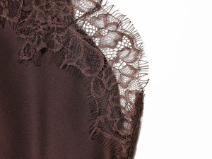 Detail of dark brown satin dress with floral lace trim and eyelash edge detailing