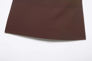 Détail de l'ourlet en sergé marron foncé avec des coutures soignées sur une mini-jupe