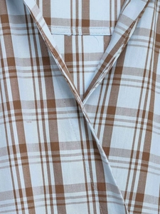 Detailaufnahme von hellblauem und braunem Karomuster-Stoff mit feinen Nähten