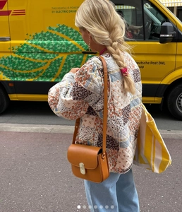 Street style view of quilted floral jacket with vintage patchwork and brown leather bag