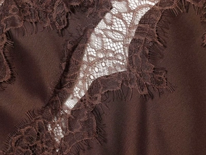 Detailed view of brown satin dress featuring delicate floral eyelash lace trim