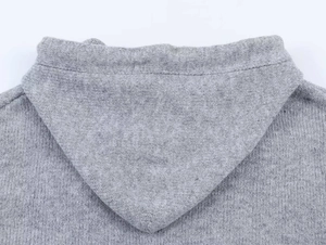Nahaufnahme der grauen Strickstruktur und des Kapuzenausschnitts der Vintage-Strickjacke