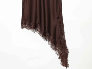 Detailed close-up of brown dress with asymmetric hemline and delicate lace trim