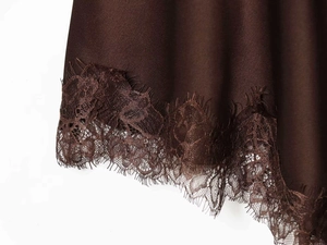 Detailed macro view of the brown satin dress featuring delicate eyelash lace trim at the hem