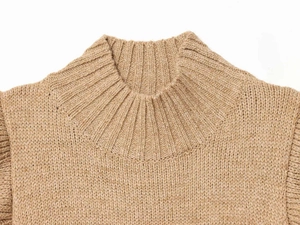 Close-up of brown knit vest showing the ribbed round neckline and soft wool texture