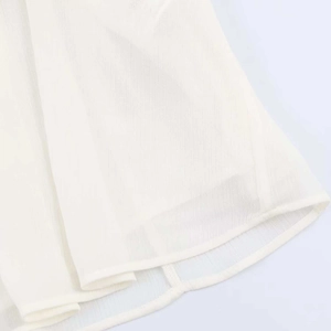 Macro shot of white chiffon shirt hem with high-quality stitching and fabric texture