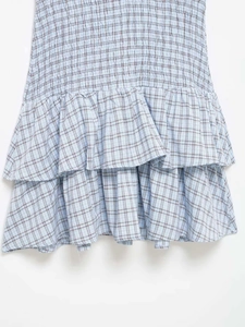 Detail of smocked plaid dress fabric with ruffles and blue checkered pattern texture
