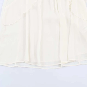 Detail of white chiffon shirt featuring elegant double-layered ruffle hem and fine stitching