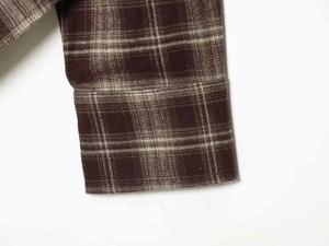 Makroaufnahme einer braun karierten Flanell-Manschette mit Köperbindung und feinen Nähten